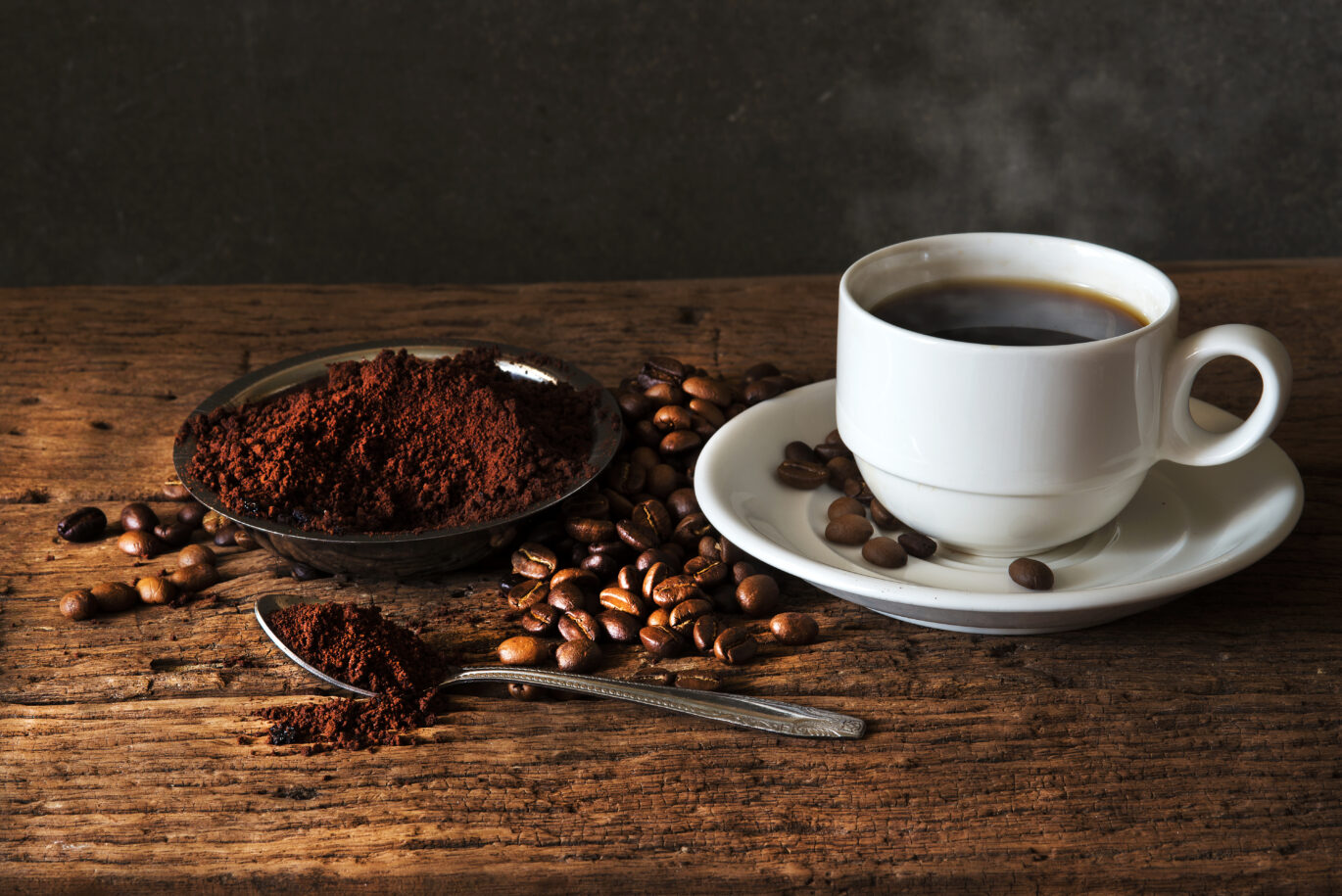 Filterkoffie in een bakje en lepel naast een kopje met koffie