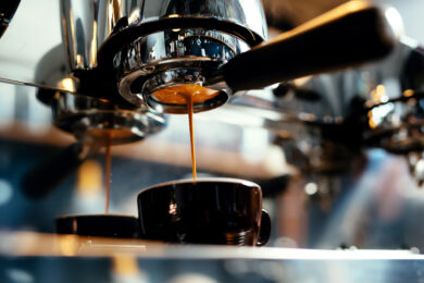 Close-up van een koffiezetapparaat die koffie zet. Deze machine kan gereinigd worden met reinigingstabletten