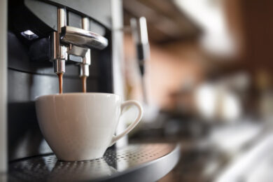 koffiemachine zet koffie in een wit kopje