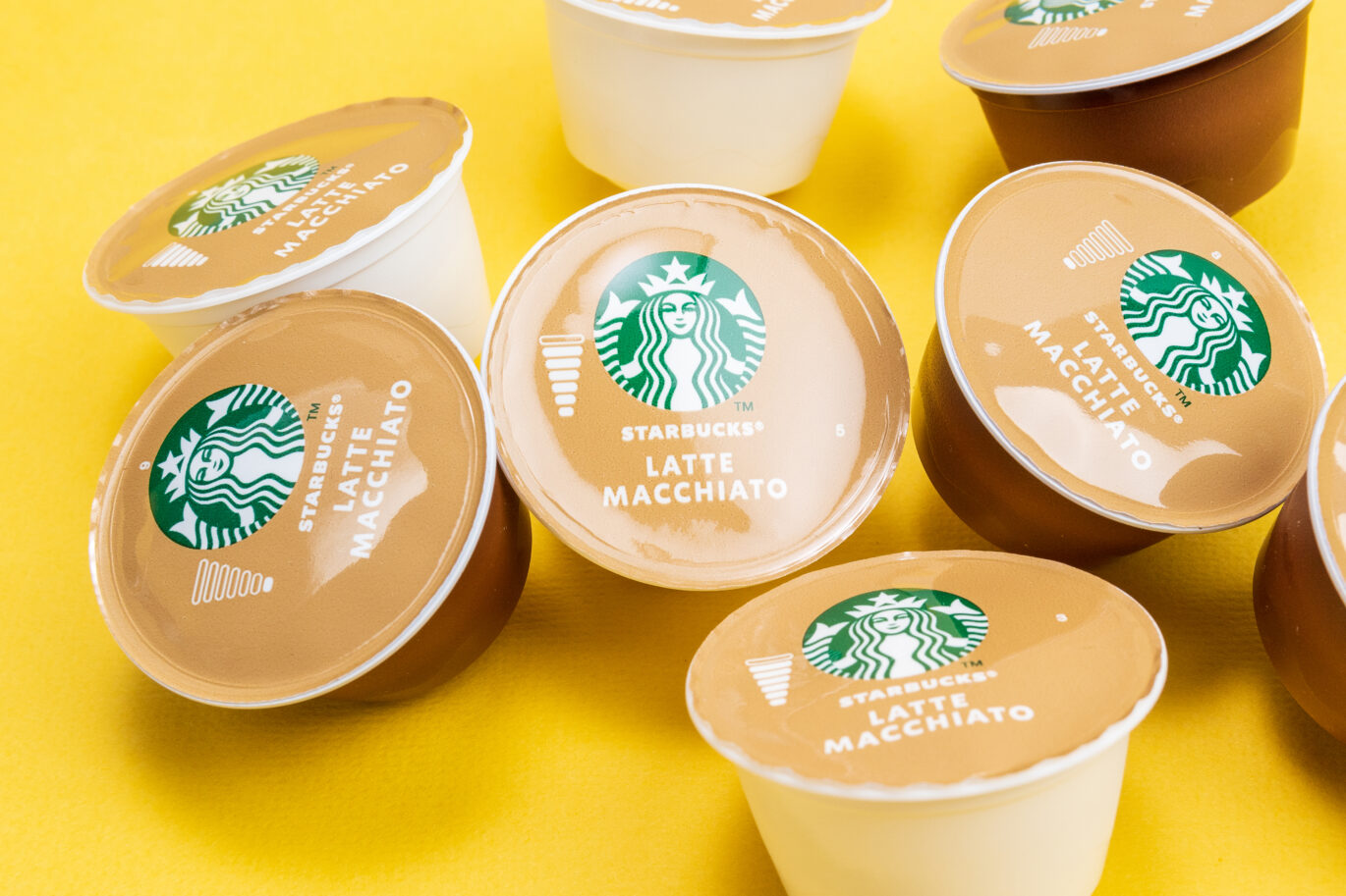 Meerdere heerlijke Starbucks cups op een gele ondergrond