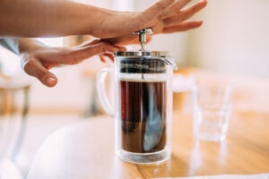 Een kofifeliefhebber die koffie zet met de french press
