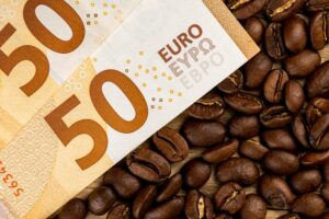 Twee vijftig euro briefjes bovenop een aantal koffiebonen. Wist je dat je zuinig koffie kunt zetten?